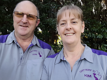 Don and Kim smiling at the camera, wearing grey and purple branded Cattery 122 Shirts